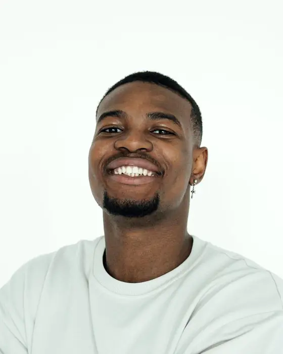 Terrence Mabry, Baltimore leasing agent, smiling with his arms crossed in a white sweater.